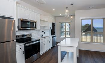 A modern kitchen with white cabinets and stainless steel appliances