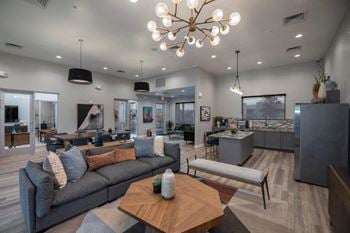 A living room with couches and a table and a chandelier