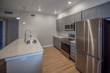 A kitchen with stainless steel appliances and a marble counter top