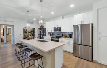 Gourmet kitchen with custom cabinetry, quartz countertops & tile backsplash