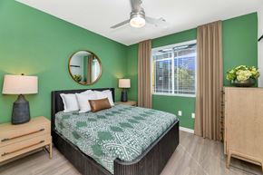 Gilbert apartment for rent - A bedroom with a bed, nightstand, and a mirror on the wall.