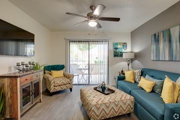 Chandler apartment for rent - A living room with a blue couch and a wooden cabinet.