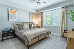 Phoenix apartment for rent - A bedroom with a bed, nightstand, and a plant.