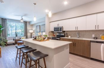 Gourmet kitchen with modern cabinetry, premium quartz countertops & tile backsplash