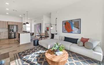 Buckeye townhouse for rent - A modern living room with a white sofa, a wooden coffee table, and a large abstract painting on the wall.