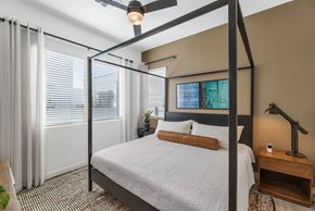 Buckeye townhouse for rent - A bedroom with a four poster bed and a ceiling fan.at Marketside Villas at Verrado, Buckeye, AZ