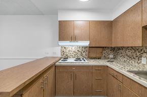 Phoenix apartment for rent - A kitchen with wooden cabinets and a white stove top oven at The Phoenix Apartments on 6th Avenue, Phoenix
