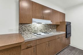 Phoenix apartment for rent - A kitchen with wooden cabinets and a tiled backsplash at The Phoenix Apartments on 6th Avenue, Arizona 85013