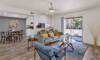 An open living room and dining room with a sliding glass door to a patio