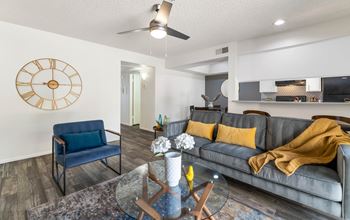 A living room with a large clock on the wall and a couch