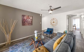 A living room with a couch and a table and a ceiling fan