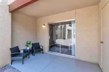A patio with two chairs and a sliding glass door