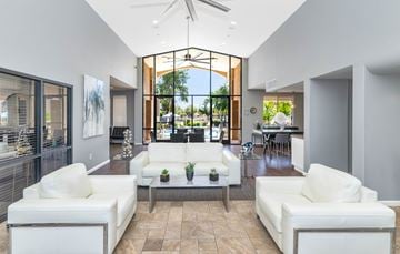 Chandler apartment for rent - A modern living room with white furniture and a large window.
