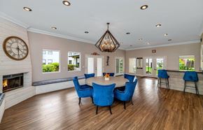 Mesa apartment for rent - A living room with a fireplace and blue chairs at Red Mountain Apartments, Mesa, AZ