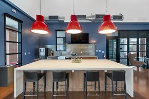 Buckeye townhouse for rent - A kitchen with a table and chairs and three red pendant lights at Marketside Villas at Verrado, Buckeye, AZ