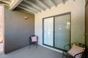 A patio with a chair and a table.