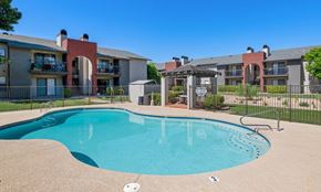 Mesa apartment for rent - A swimming pool in front of apartment buildings at Reflections at Red Mountain Apartments, Mesa, Arizona