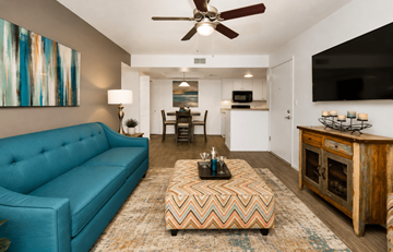 Chandler apartment for rent - A living room with a blue couch and a chevron patterned ottoman.