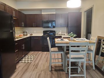 Sedona apartment for rent - A kitchen with a black refrigerator and a dining table with chairs.