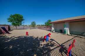 Prescott Valley apartment for rent - two red fire hydrants in a fenced in play area with a building