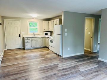Quechee apartment for rent - A kitchen with a white refrigerator and wooden floors.