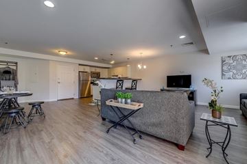 Manchester apartment for rent - A living room with a grey couch and a dining table.