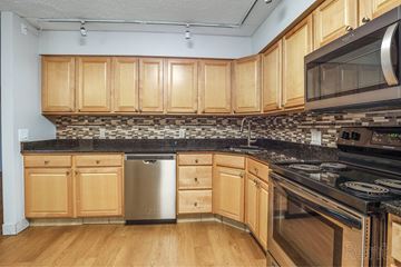 South Portland apartment for rent - A kitchen with wooden cabinets and a black countertop.