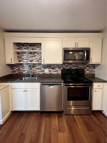 Cape Elizabeth apartment for rent - A kitchen with white cabinets and a black stove top oven.