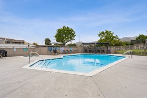 Lompoc apartment for rent - Lompoc, CA, Apartments - Oceanwood Apartments - A Large Outdoor Swimming Pool Features A Wide Concrete Deck, Metal Handrails, Lounge Seating Under Shade Structures, And A Fenced Perimeter.