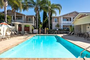 Ventura apartment for rent - 2-Bedroom Apartments in Ventura, CA - Ralston Courtyards - Pool With Spacious Sundeck, Lounge Chairs, Umbrellas, And Palm Trees.
