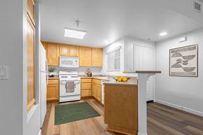 Goleta apartment for rent - Goleta, CA, Apartments Near Starbucks - Willow Springs - Kitchen with Wood-Style Flooring, Breakfast Bar, Tan Cabinets and White Appliances