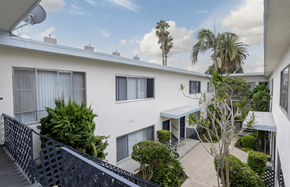 Los Angeles apartment for rent - A white building with a balcony and a black railing.