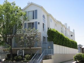 Los Angeles apartment for rent - A white building with a green hedge on the side.