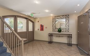 Los Angeles apartment for rent - A hallway with a bench, a fire extinguisher, and a mirror.