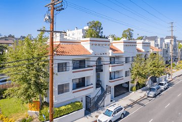 Los Angeles apartment for rent - a white and orange apartment building with cars parked in front of it