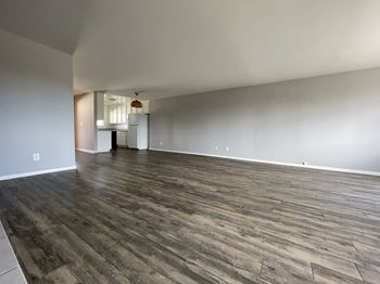 A room with hard wood inspired vinyl flooring and white walls 