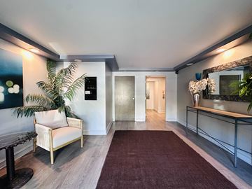 Los Angeles apartment for rent - A living room with a sofa, a table, a plant, and a red carpet.
