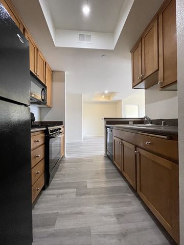 Los Angeles apartment for rent - A modern kitchen with wooden cabinets and black appliances.