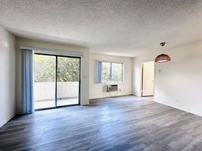 Los Angeles apartment for rent - A spacious room with a sliding glass door and a wooden floor.at Lido Apartments - 10535 Rose Ave, Los Angeles, CA, 90034