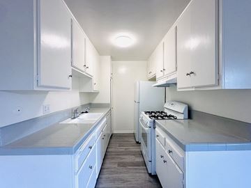 Los Angeles apartment for rent - A kitchen with white cabinets and a stove top oven.