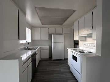 Anaheim apartment for rent - A white kitchen with a refrigerator, oven, and sink.