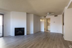 Anaheim apartment for rent - A living room with a fireplace and a fan on the ceiling.at Lido Apartments - 101-197 N Ridgeway, Anaheim, CA 92801