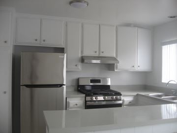 Costa Mesa apartment for rent - A kitchen with white cabinets and stainless steel appliances.