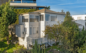 Los Angeles apartment for rent - A house with a balcony surrounded by trees and bushes.