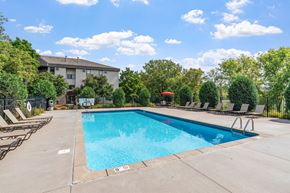 Plymouth apartment for rent - a swimming pool with chairs and a building in the background