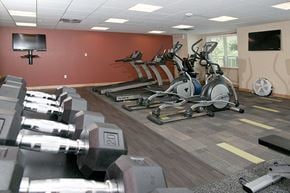 New Brighton apartment for rent - a gym with weights and a tv on the wall