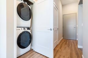 Bloomington apartment for rent - A white door is open to a hallway with a washer and dryer in the other room.
