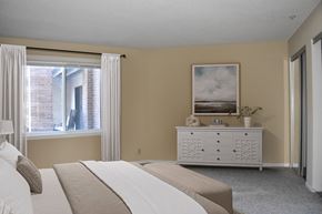 St. Paul apartment for rent - A bedroom with a large bed and a painting on the wall.