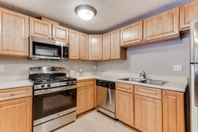 Edina apartment for rent - A kitchen with wooden cabinets and stainless steel appliances.
