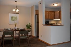Hopkins apartment for rent - A dining room with a table set for two and a kitchen area in the background.